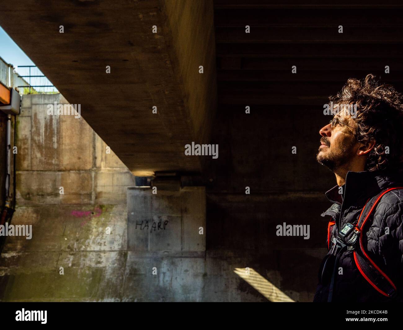 A walker is standing up under a bridge looking at the sun, during the Spring temperatures in The Netherlands, on April 28th, 2021. (Photo by Romy Arroyo Fernandez/NurPhoto) Stock Photo