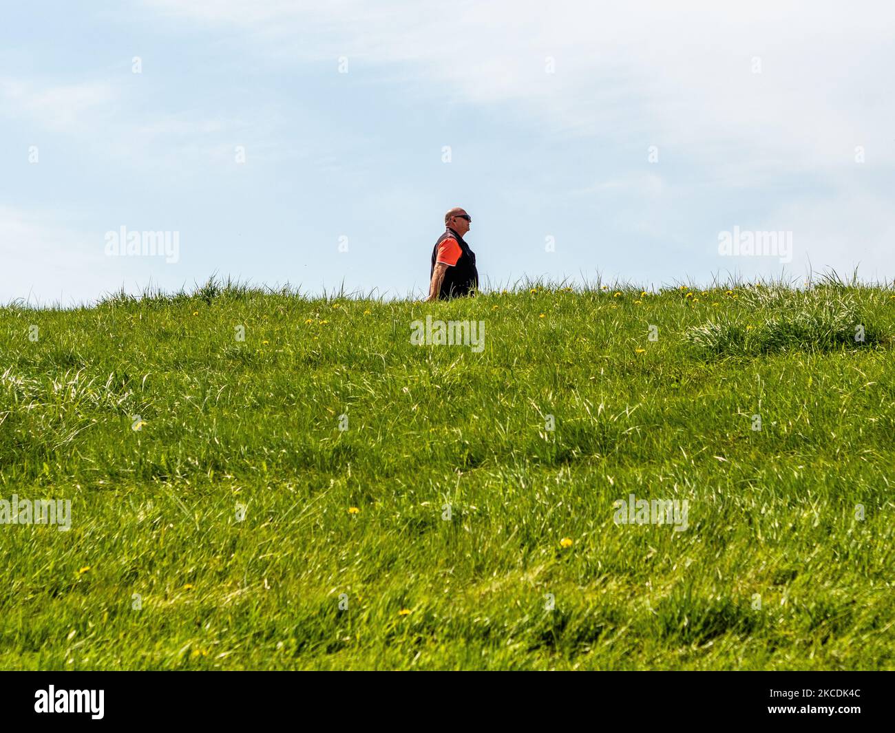 A man is walking around a dike, during the Spring temperatures in The Netherlands, on April 28th, 2021. (Photo by Romy Arroyo Fernandez/NurPhoto) Stock Photo