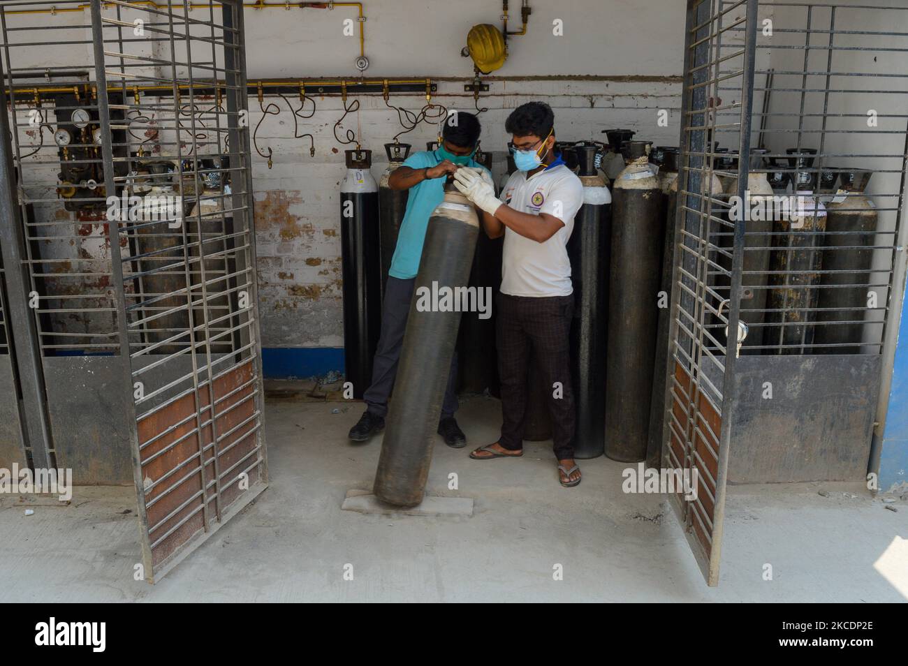 Health workers carrying out filled cylinders of oxygen from a generation plant inside a government sponsored COVID-19 care hospital in Kolkata , India , on 1 May 2021 . The Indian Government are trying working overtime to set up a number of oxygen generation plant at COVID hospitals around the country to address the issue of oxygen shortage that has plagued the country during the second wave of COVID-19 outbreak . India yesterday recorded over 4 Lakh cases , the highest peak ever recorded in the world according to Indian media report . (Photo by Debarchan Chatterjee/NurPhoto) Stock Photo