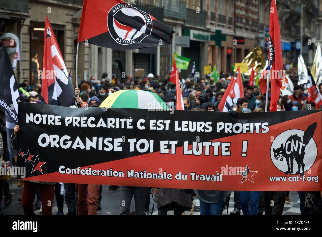 A banner from the CNT union reads 'Our precarity is their profits. Organize yourself and fight'. Thousands of people took to the streets for Labour Day in Toulouse. This year, the motto was about culture and the reform of unemployment benefits. Artists made several stops to dance and to sing during the march. One of the stops took place in front of the occupied National Theater of Toulouse ('TheatreDeLaCite') where they performed 'We want to go on dancing' by Alexis HK. Toulouse, France on May 1st 2021. (Photo by Alain Pitton/NurPhoto) Stock Photo