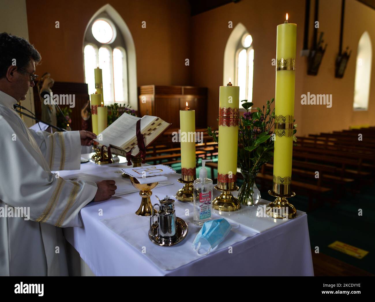 Father Krzysztof Sikora during a private prayer at the closed and empty Roman Catholic Church 'Our Lady Star Of The Sea' in Roundstone. Due to Covid-19 restrictions, all religious ceremonies are still canceled. Geographically, Roundstone parish is considered Ireland's largest parish and stretches from the Gurteen Beaches to the Twelve Bens and Mám Tuirc Mountains. Until the 1990s, the parish was served by three priests, now there is only one to look after five churches. The current Parish Priest, a Polish born Fr Krzysztof Sikora, is a member of the religious congregation of the Divine Word Mi Stock Photo