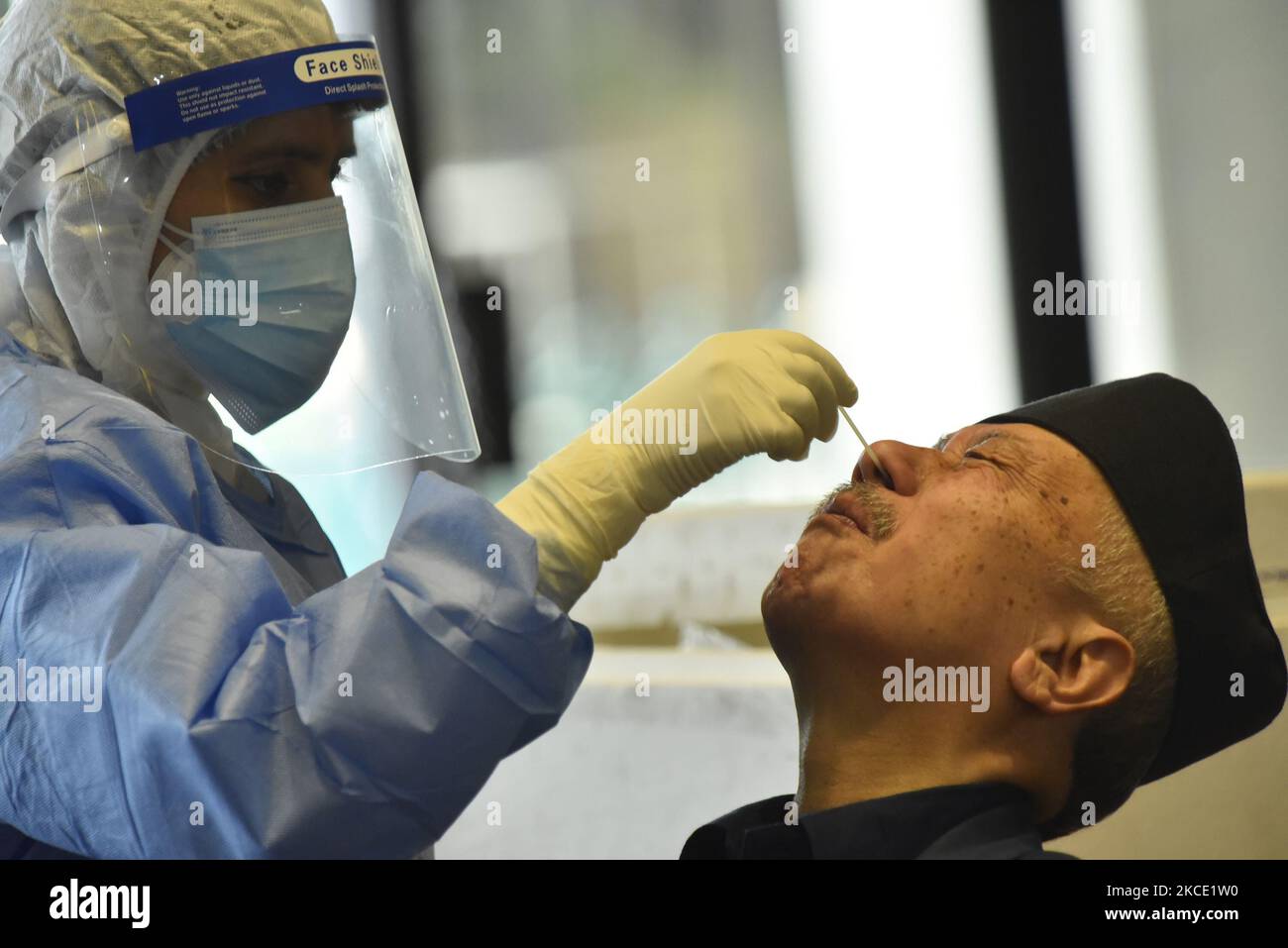A Nepalese Health personnel collect nasal swab sample of Former