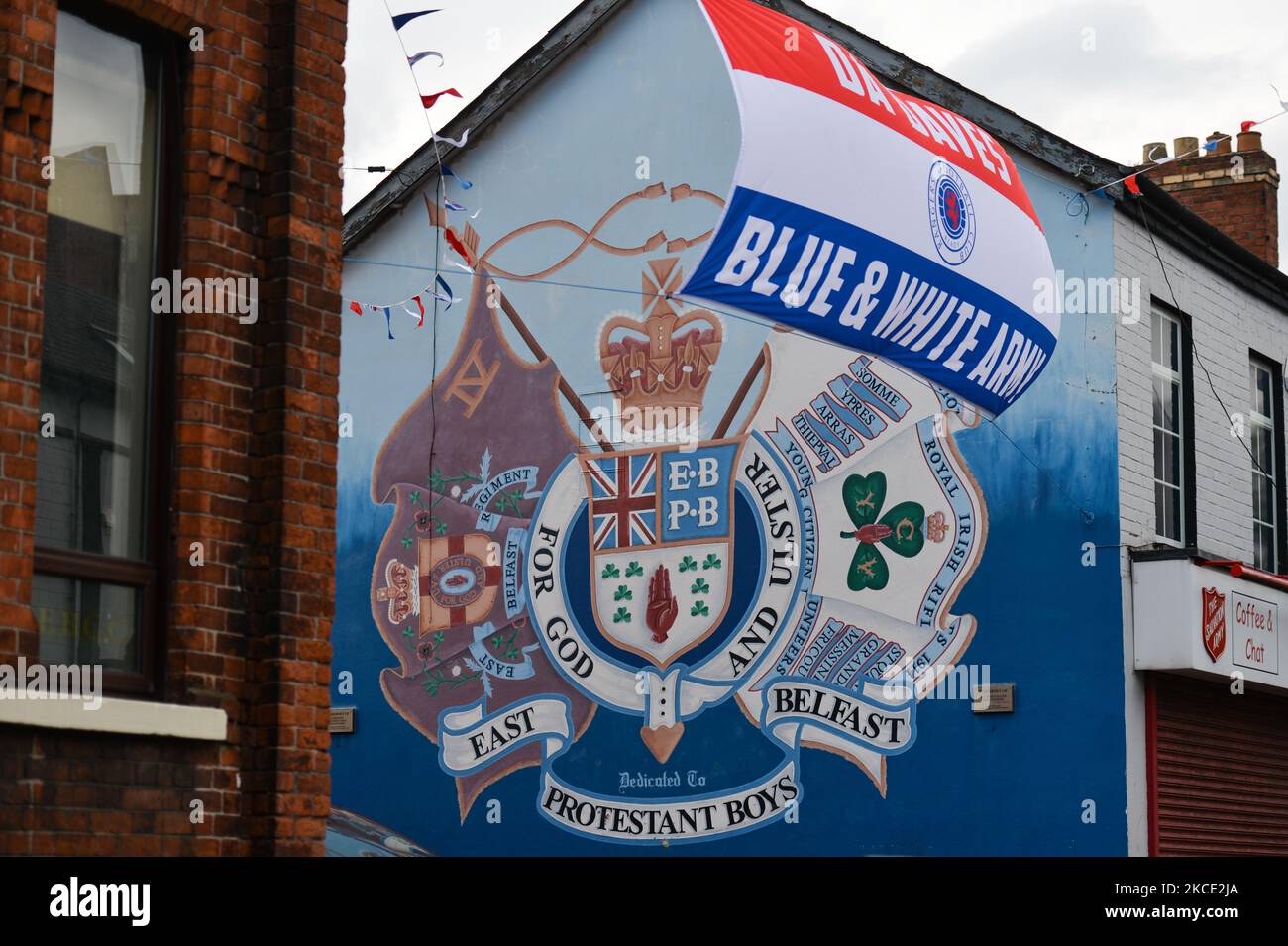 Rangers supporters flag seen next to a political mural in East Belfast. On Monday, April 19, 2021, in Belfast, Northern Ireland (Photo by Artur Widak/NurPhoto) Stock Photo