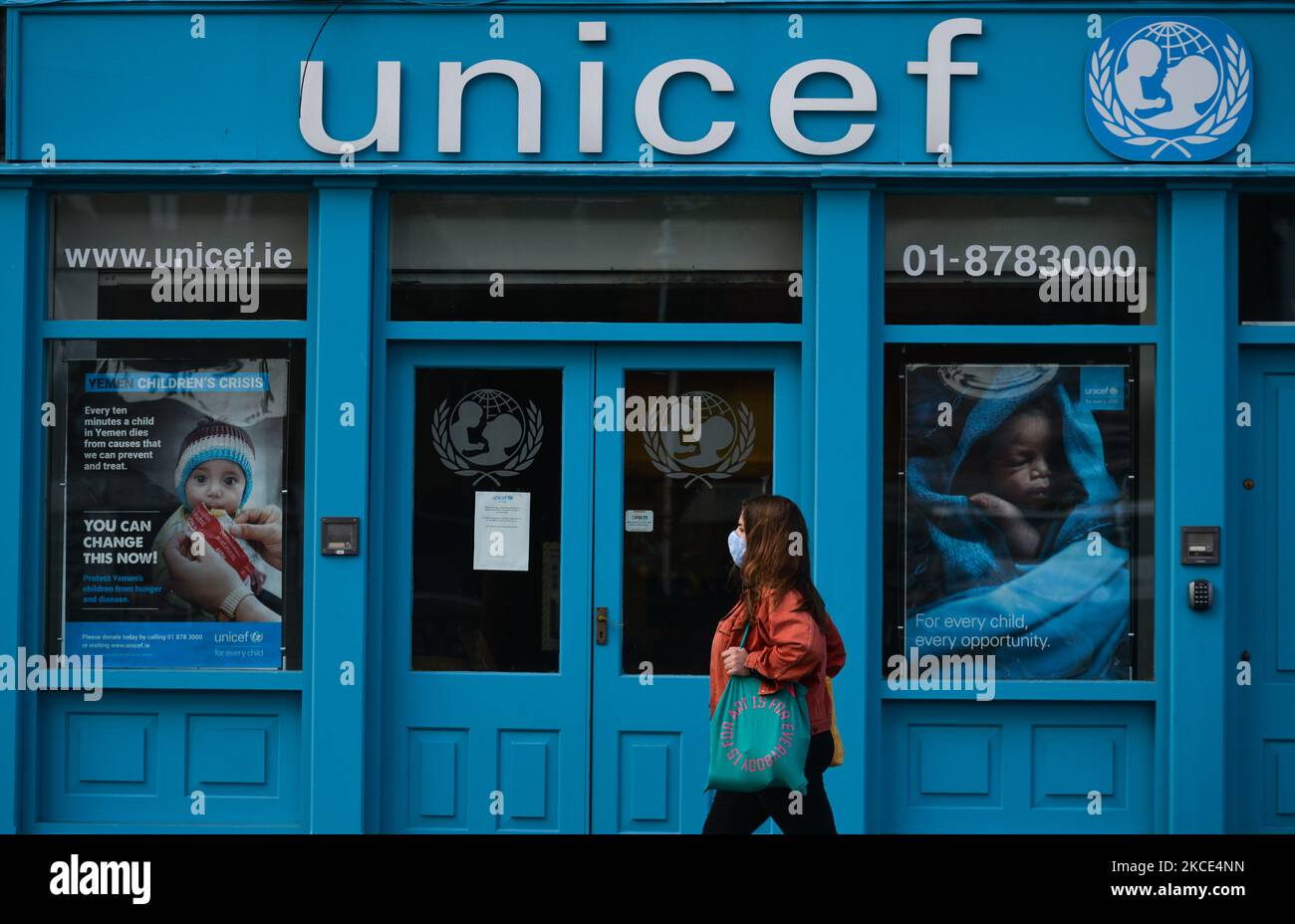 A woman wearing a face mask walks in front of UNICEF office in Dublin during the final days of the COVID-19 lockdown. On Friday, 7 May 2021, in Dublin, Ireland. (Photo by Artur Widak/NurPhoto) Stock Photo