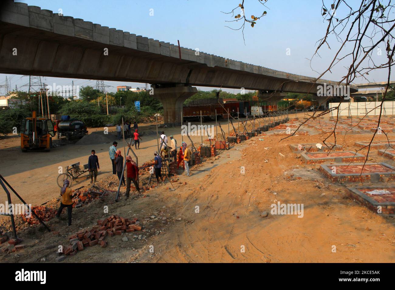 Workers construct new platforms to cremate bodies outside a crematorium, amidst the spread of coronavirus cases in New Delhi, India on May 8, 2021. India recorded over 4 lakh new Covid-19 cases in the last 24 hours, taking the country's total caseload to over 2.18 crore. With 4,187 new deaths, the toll now stands at over 2.38 lakh. (Photo by Mayank Makhija/NurPhoto) Stock Photo