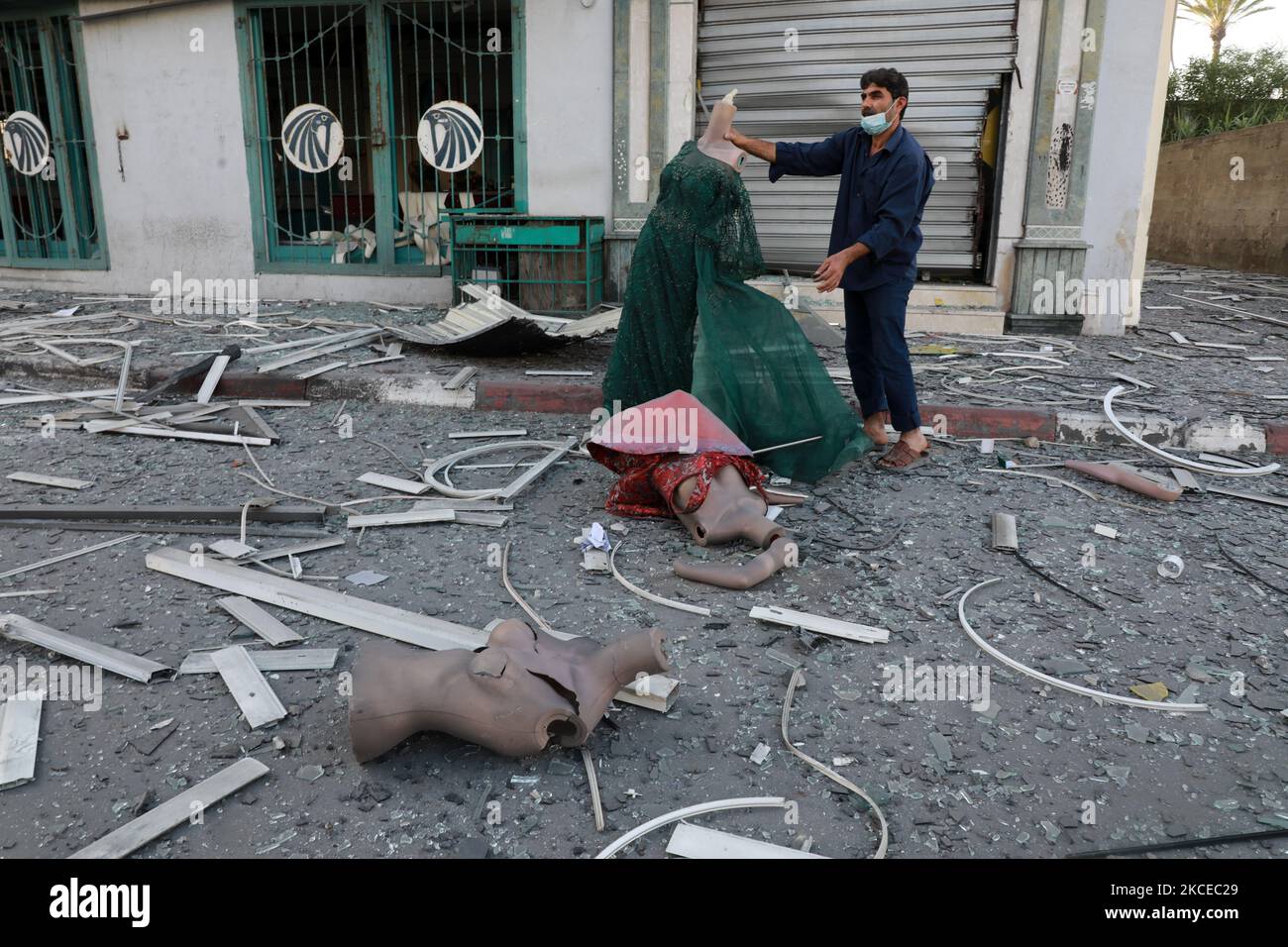 A Palestinian man inspects the debris early on May 12, 2021 outside the heavily-damaged Al-Jawhara Tower in Gaza City which was hit by Israeli airstrikes overnight. - Israeli air raids in the Gaza Strip have hit the homes of high-ranking members of the Hamas militant group, the military said Wednesday, with the territory's police headquarters also targeted. (Photo by Majdi Fathi/NurPhoto) Stock Photo