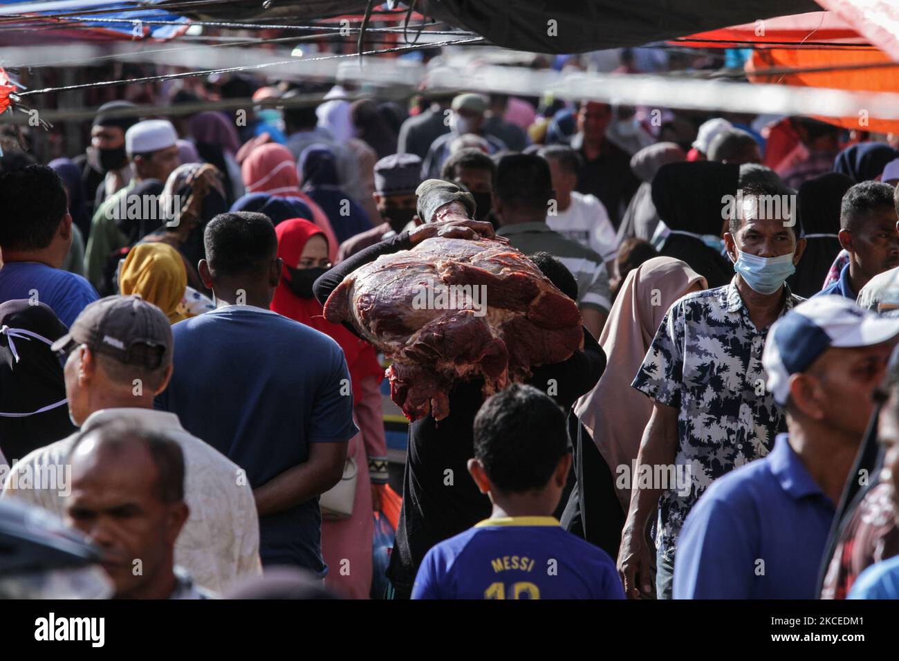 People are seen gathering a traditional market to buy meat, as a tradition before celebrating Eid al-Fitr called' Meugang' in Lhokseumawe, on May 12, 2021, Aceh Province, Indonesia. Acehnese people continue to carry out the 'Meugang' tradition that has lasted for hundreds of years, each family buying and cooking meat before Ramadan, Eid al-Fitr, and Eid al-Adha. (Photo by Fachrul Reza/NurPhoto) Stock Photo
