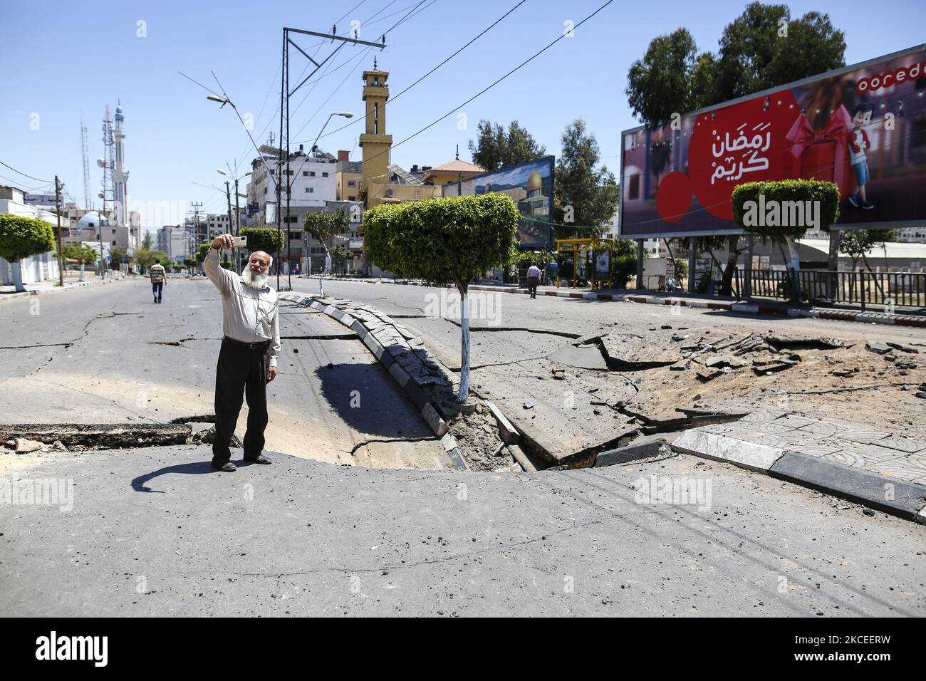 A Palestinian man take pictures with his smart phone of a huge crater ...