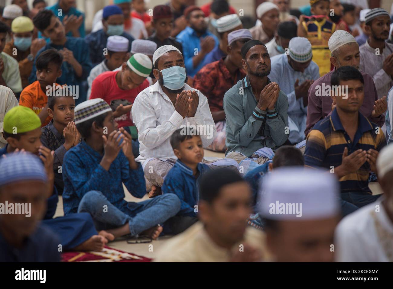 People are praying outside of a mosque on 14 May 2021 at Bogra in