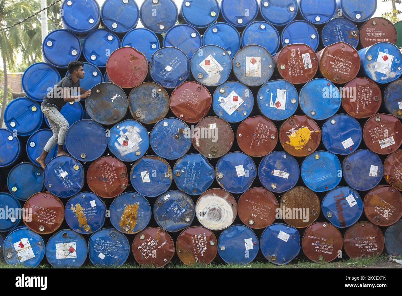 A worker stack empty oil drums for recycling at a warehouse in Narayanganj on May 19, 2021