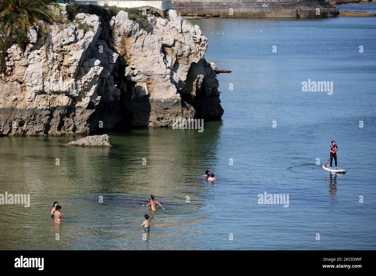People swim at the beach in Cascais, Portugal on May 19, 2021. British