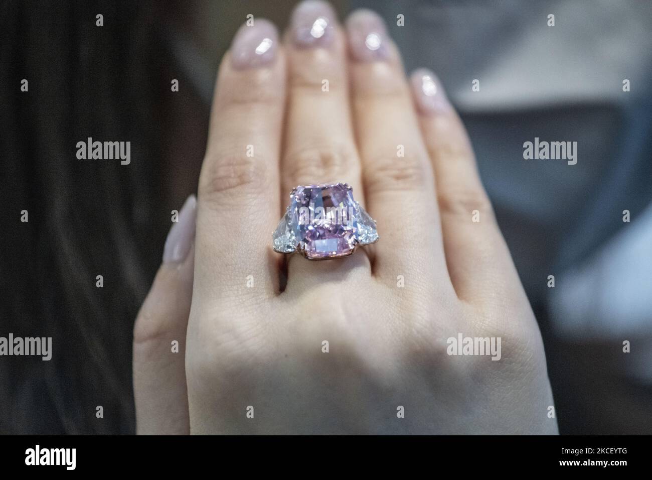 A woman displays the Sakura Diamond during preview at Christie's in Hong Kong, China, 20 May 2021. The 15.81 Carat Fancy Vivid Purple Pink Internally Flawless Type lla Diamond Ring will be auctioned in Hong Kong on 23 May 2021 for an estimated 25 million to 38 million US dollars. (Photo by Vernon Yuen/NurPhoto) Stock Photo