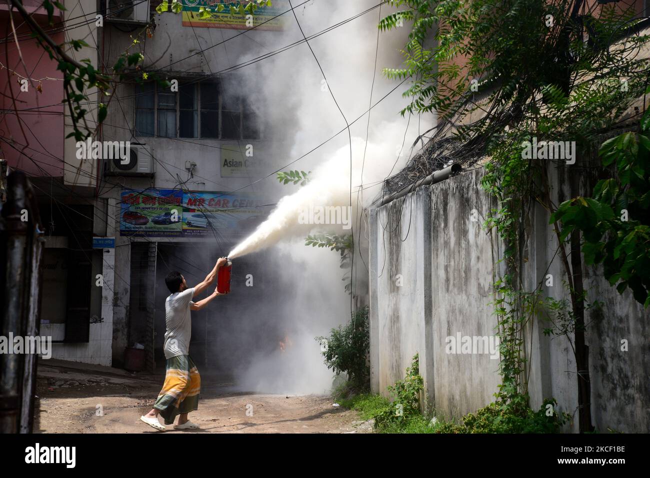 People try to extinguish a fire in a high-rise building at Kakrail in ...