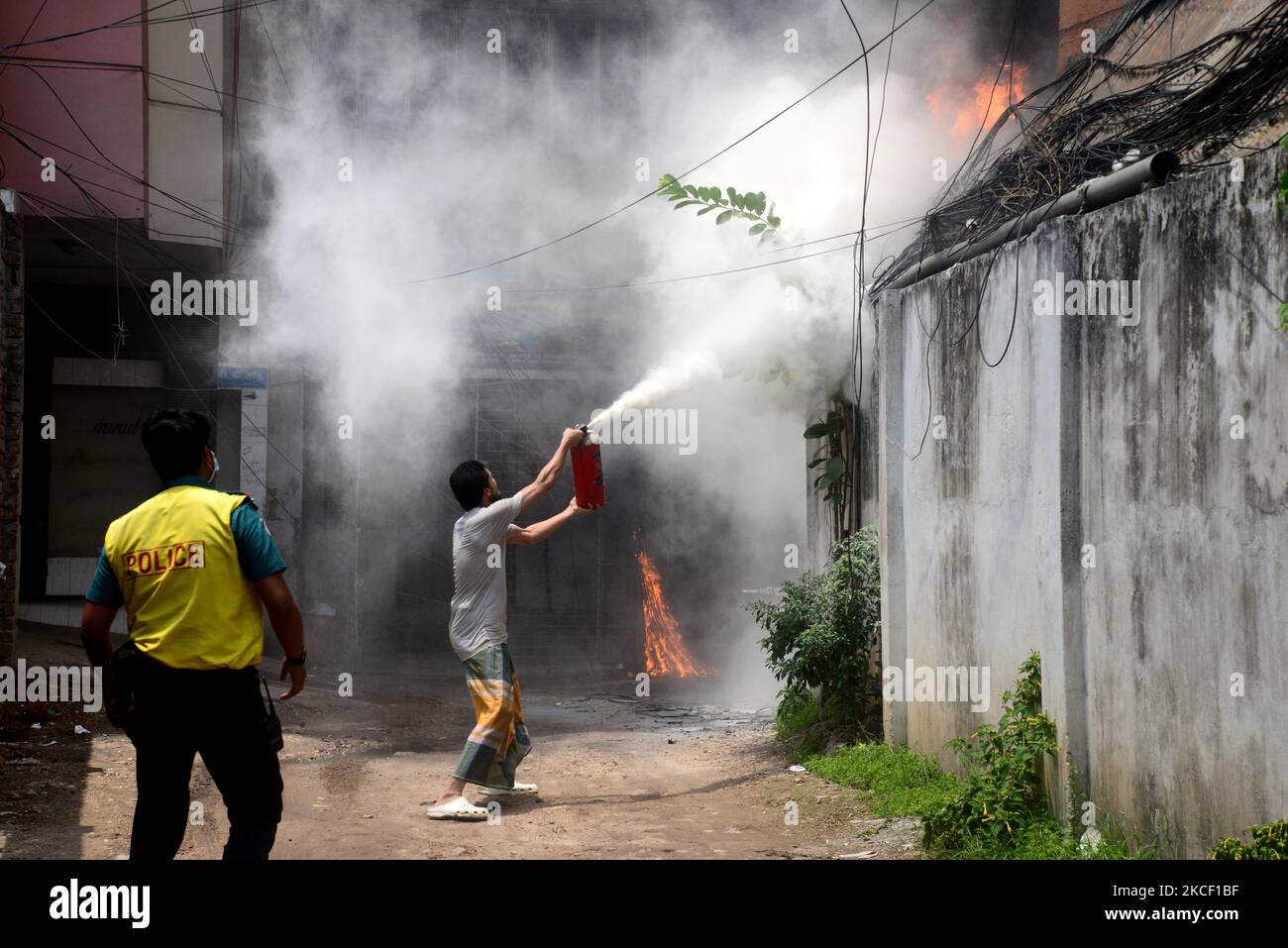 People try to extinguish a fire in a high-rise building at Kakrail in ...