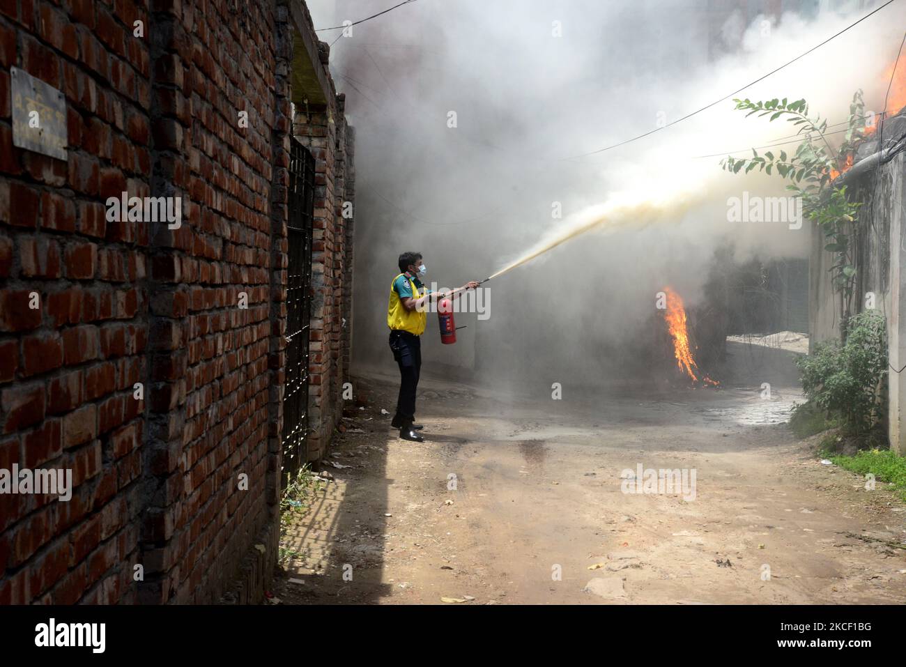 People try to extinguish a fire in a high-rise building at Kakrail in ...
