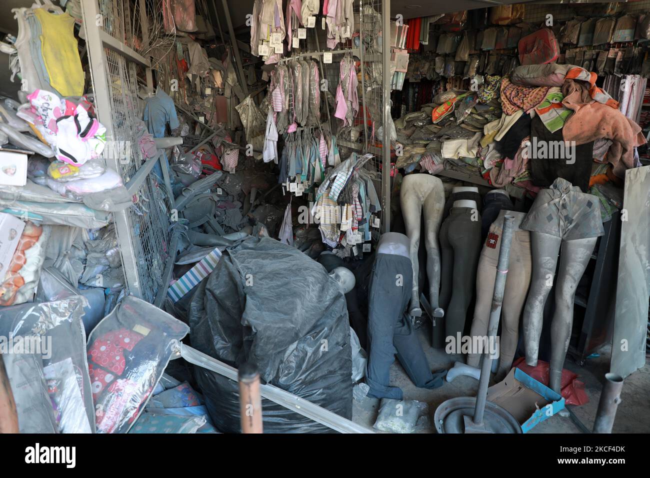 A picture shows damaged stores in a shopping center, next to a building ...