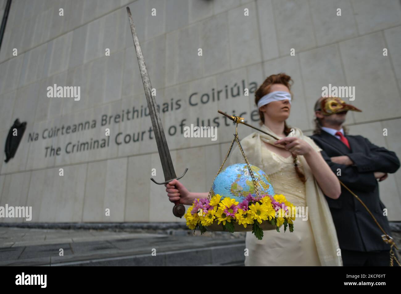 Extinction Rebellion activists, Ceara Carney dresses blindfolded in a gown as Lady Justice and Louis Heath wearing a suit to represent the state seen during a theatrical protest on the steps of the Criminal Court of Justice in Dublin to show the injustice of climate inaction as 20-year-old Orla Murphy, a climate activist, appears in court for criminal damages. On Tuesday, May 25, 2021, in Dublin, Ireland. (Photo by Artur Widak/NurPhoto) Stock Photo
