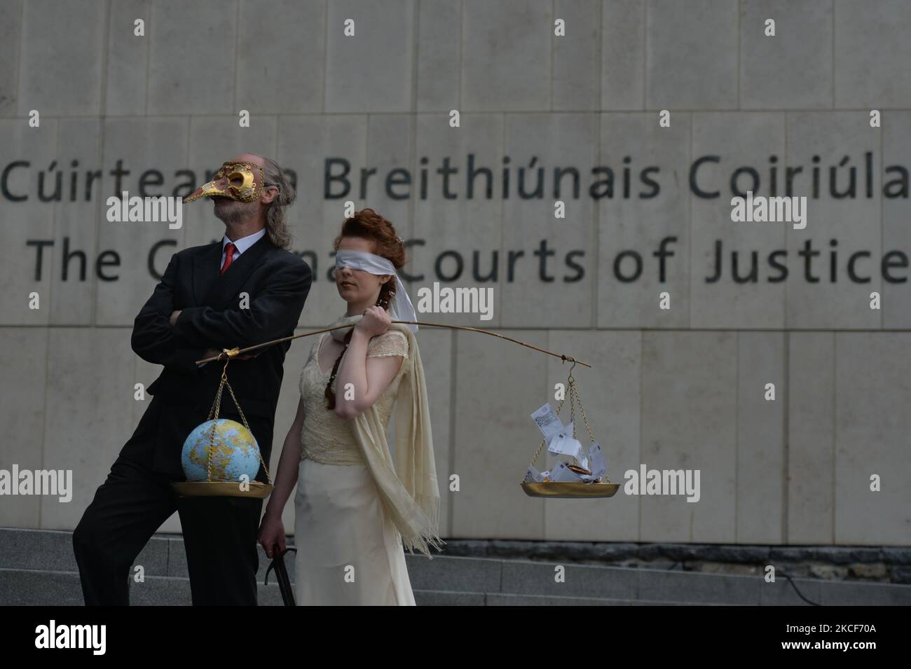 Extinction Rebellion activists, Ceara Carney dresses blindfolded in a gown as Lady Justice and Louis Heath wearing a suit to represent the state seen during a theatrical protest on the steps of the Criminal Court of Justice in Dublin to show the injustice of climate inaction as 20-year-old Orla Murphy, a climate activist, appears in court for criminal damages. On Tuesday, May 25, 2021, in Dublin, Ireland. (Photo by Artur Widak/NurPhoto) Stock Photo