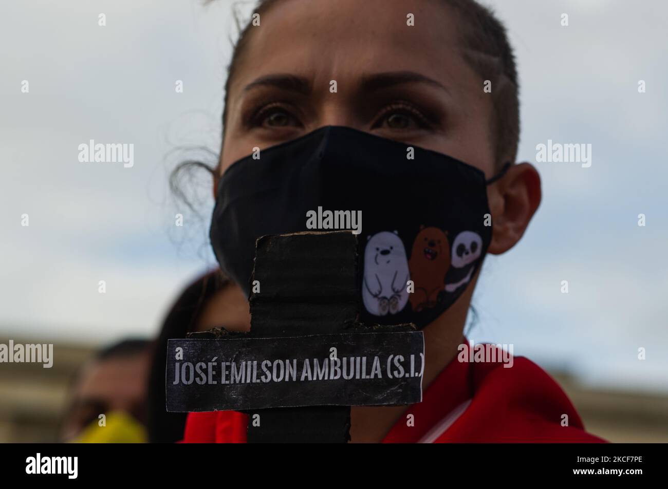 A demonstrator holds a black cross with the name of a demonstrator dead in a police brutality case during the protests as people gather at Plaza de Bolivar in front of the Congress Capitol to support the motion censure to Colombia's Defense Minister Diego Molano after at least 45 deaths in police brutality cases during the ongoing anti-government protests against tax and health reforms and police brutality evolved in Colombia for the last weeks, in Bogota, Colombia on May 24, 2021. (Photo by Sebastian Barros/NurPhoto) Stock Photo