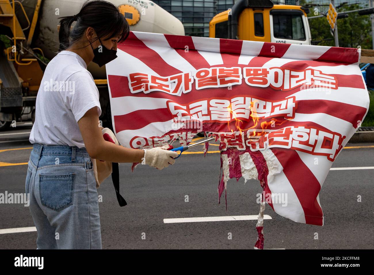 Members of the Korean University Student Progressive Association burn the Japanese war criminal flag to condemn the Tokyo Olympic Committee, which marks Dokdo Island, the territory of the Republic of Korea, as Japanese territory at across the Japanese Embassy on June 1st, 2020 in Seoul, South Korea. (Photo by Chris Jung/NurPhoto) Stock Photo