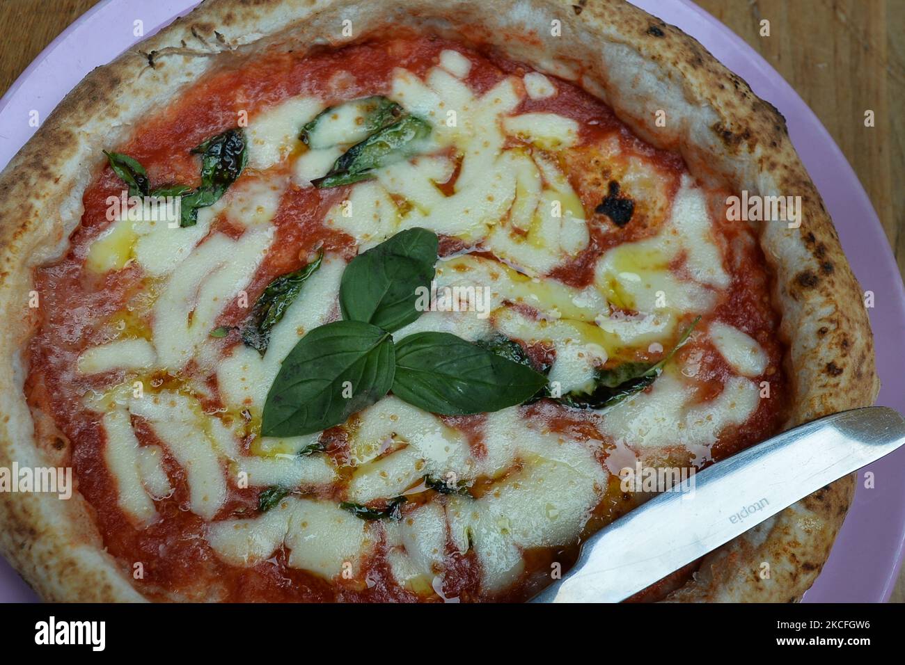 Pizza Margherita seen on the table in front of the Pygmalion bar and