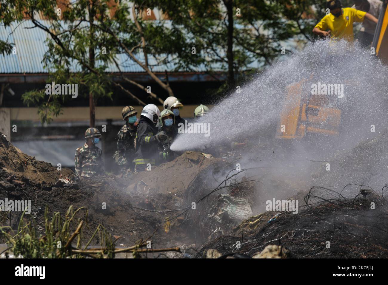 Firefighters try to douse a fire on a pile of wires at the premises of Waste Management Section in Kathmandu, Nepal on June 3, 2021. (Photo by Sunil Pradhan/NurPhoto) Stock Photo