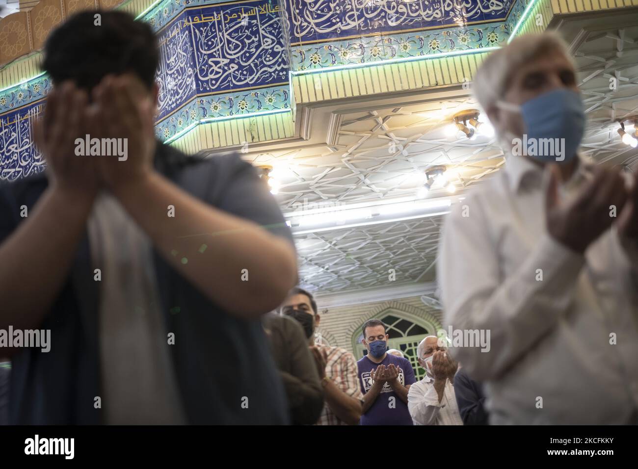 Iranian Shi’ite Muslims pray during a mass prayer ceremony at a mosque