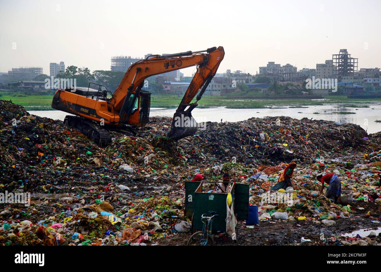 People waste pickers pick the non- biodegradable waste to be used for the recycling industry in dump site in Dhaka, Bangladesh on June 5, 2021. Although the normal instincts of the citizens dictate them to avoid passing the toxic dump yard at all costs, there is a huge group of people who eke out a living from collecting ands selling 'Bhangari' (local scrap collecting). (Photo by Sony Ramany/NurPhoto) Stock Photo