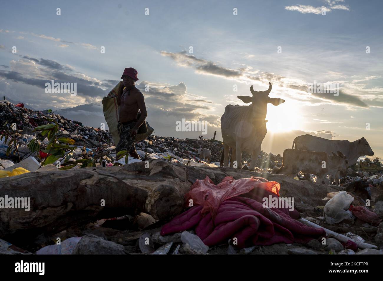 A scavenger carries used goods from his scavenged garbage at the Poi