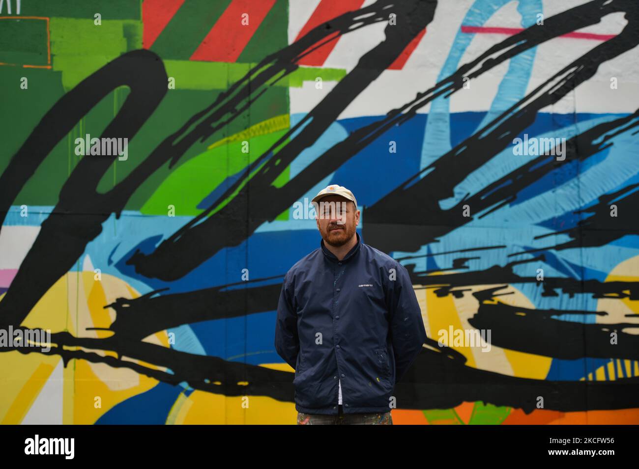 Irish artist Maser, in front of his new mural located at the corner of