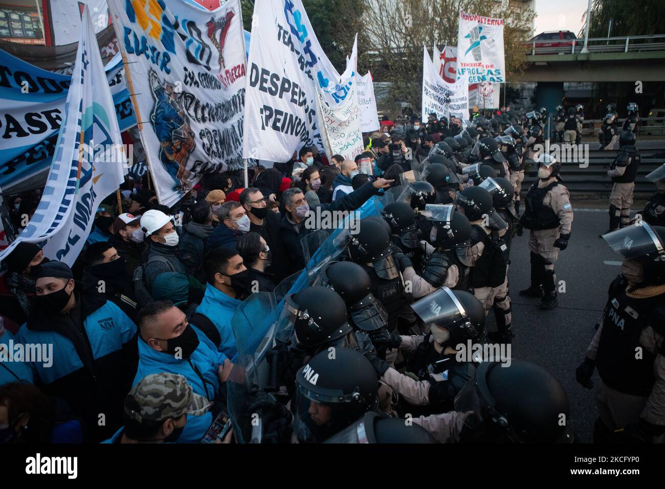 Demonstrators stand in front of riot police during a protest held by ...