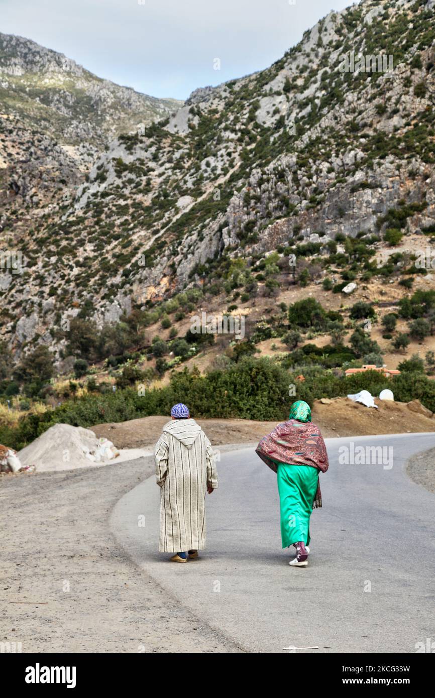 Berber couple walks along a road near city of Chefchaouen located in the Rif Mountains in Morocco, Africa. Chefchaouen (also called Chaouen) is known as the 'Blue City' due to the fact that many of its buildings are painted blue in colour, which is said to symbolize the sky and heaven, and serve as a reminder to lead a spiritual life. (Photo by Creative Touch Imaging Ltd./NurPhoto) Stock Photo