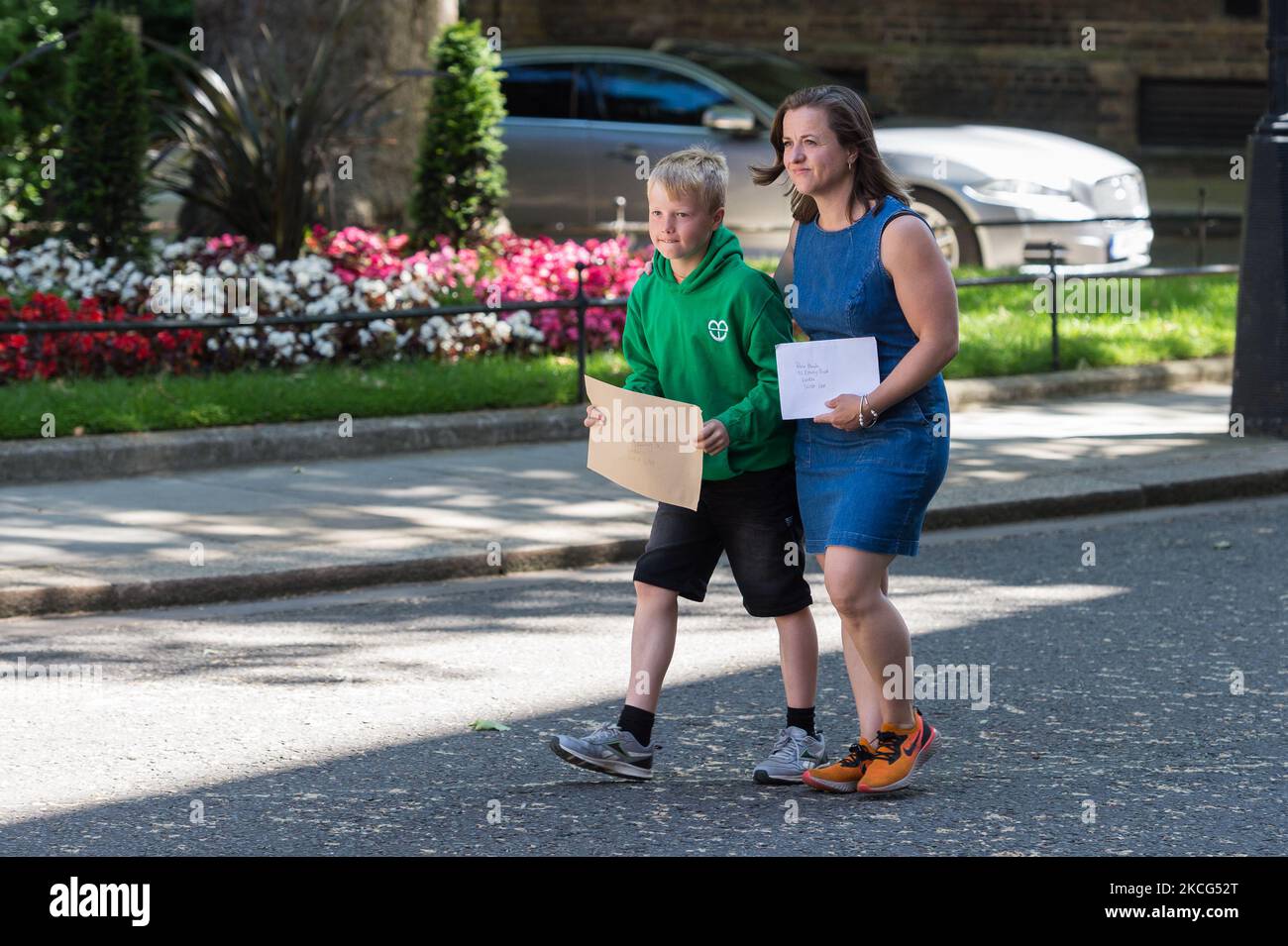LONDON, UNITED KINGDOM - JUNE 16, 2021: Thomas Braun, 9, and his mother Ilmarie Braun deliver a letter addressed to British Prime Minister Boris Johnson at 10 Downing Street asking for help in getting a medical cannabis prescription for a severely epileptic Thomas's younger brother Eddie, 3, who can suffer up to 100 seizures a day, on June 16, 2021 in London, England. The use of cannabis-based medicinal products with a prescription was made legal in 2018 for those with exceptional clinical needs but since then the NHS issued only a handful of prescriptions forcing families to pay thousands of  Stock Photo