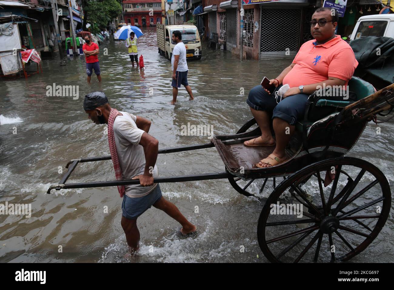 A rickshaw puller waded through a flooded street at the Heavy monsoon ...