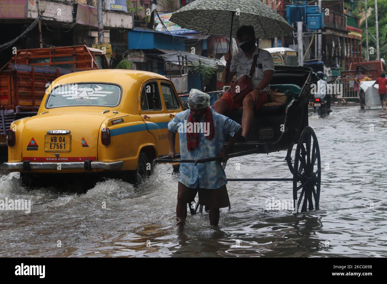 A rickshaw puller waded through a flooded street at the Heavy monsoon ...