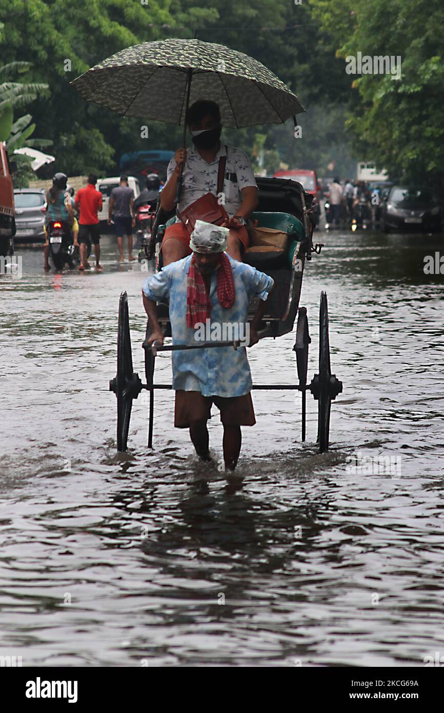 A rickshaw puller waded through a flooded street at the Heavy monsoon ...