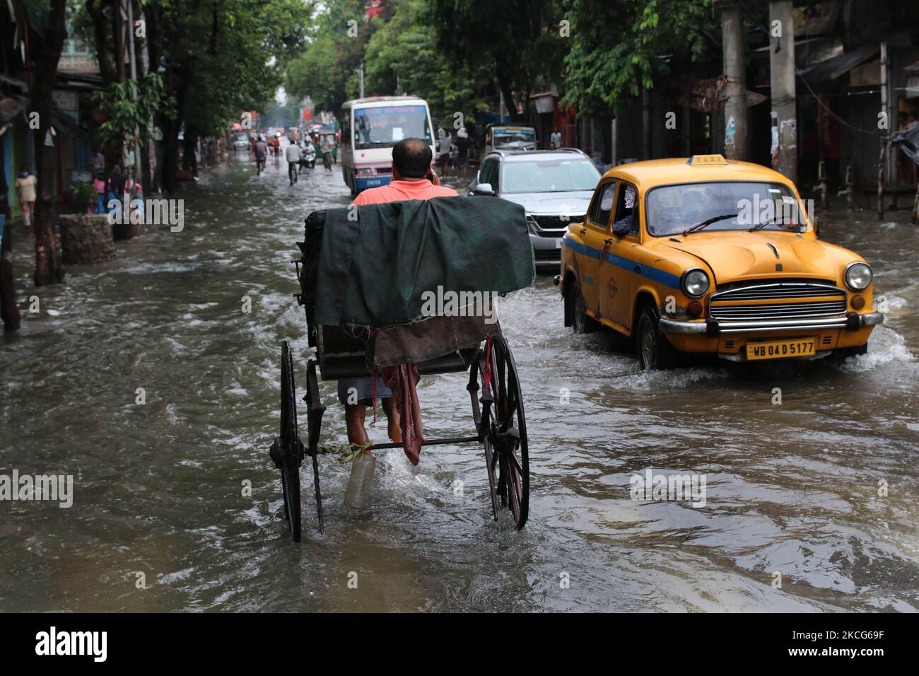 A rickshaw puller waded through a flooded street at the Heavy monsoon ...