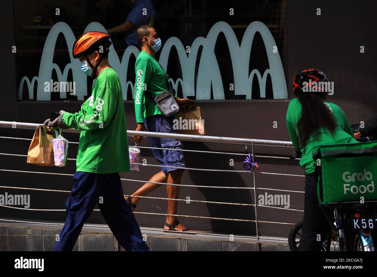 GrabFood delivery riders are seen leaving a McDonald’s restaurant with ...