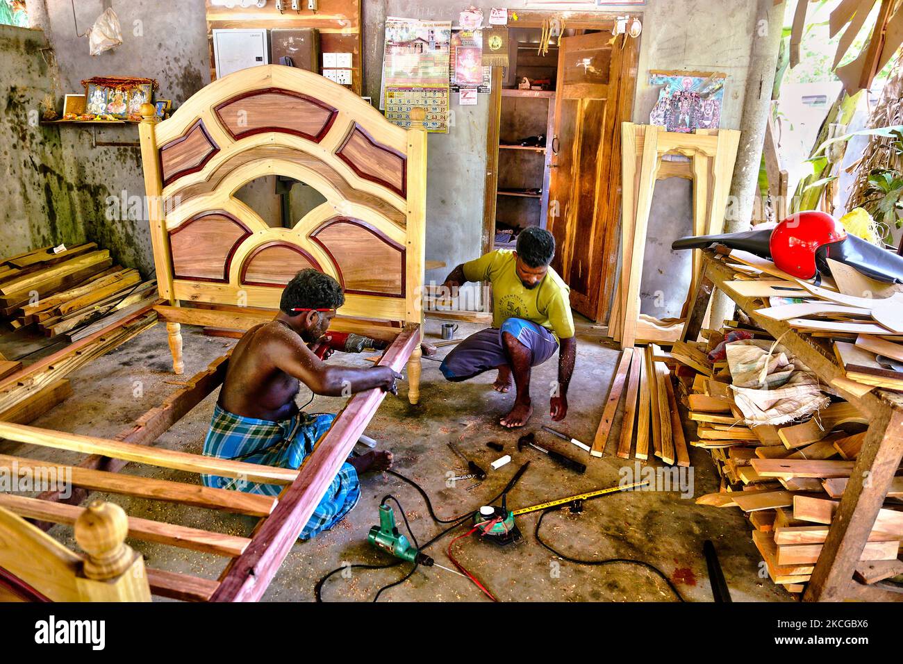 Carpenters construct a fancy wooden bed frame at a small in