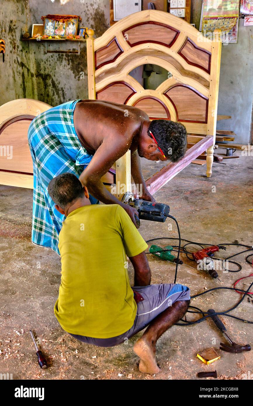 Carpenters construct a fancy wooden bed frame at a small in