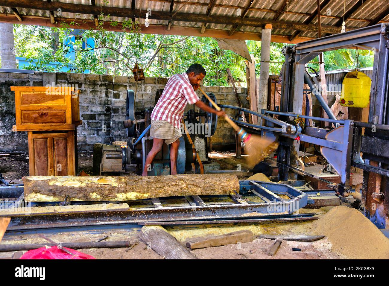 Worker sweeping sawdust at a small in Jaffna, Sri Lanka. This