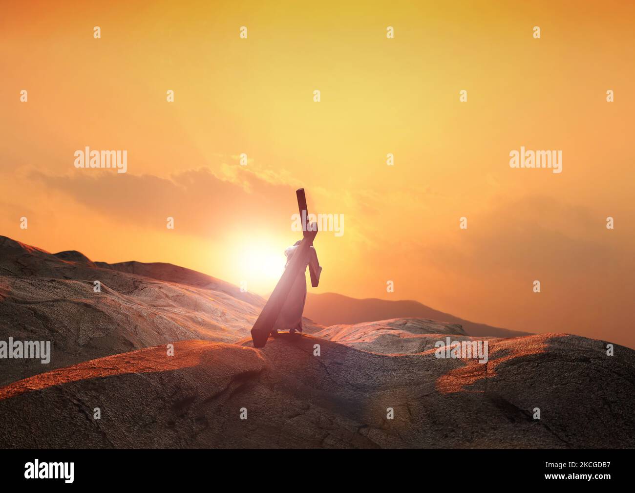 Jesus carrying the cross of suffering that symbolizes the light and clouds of the hill at sunset and death, sacrifice, and resurrection Stock Photo