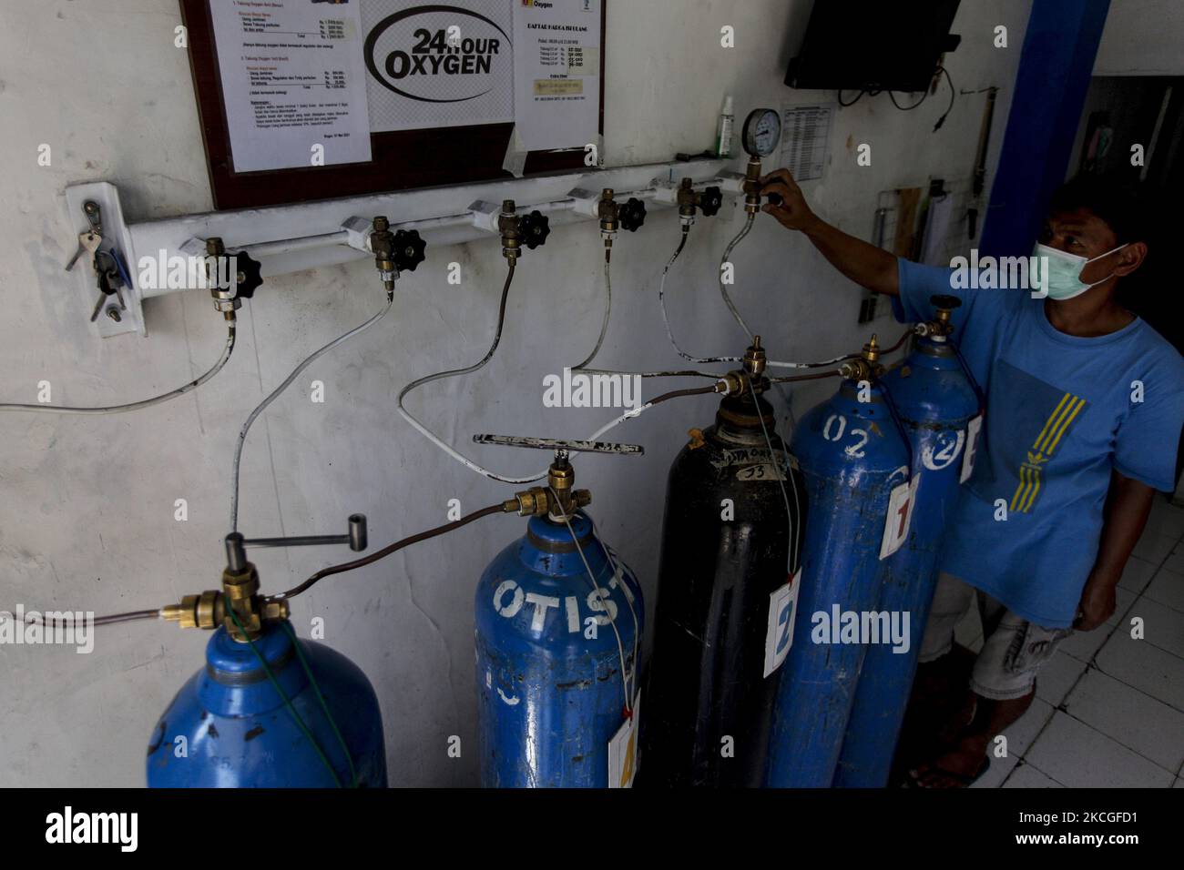 A worker refills oxygen cylinder for treating patients as the demand