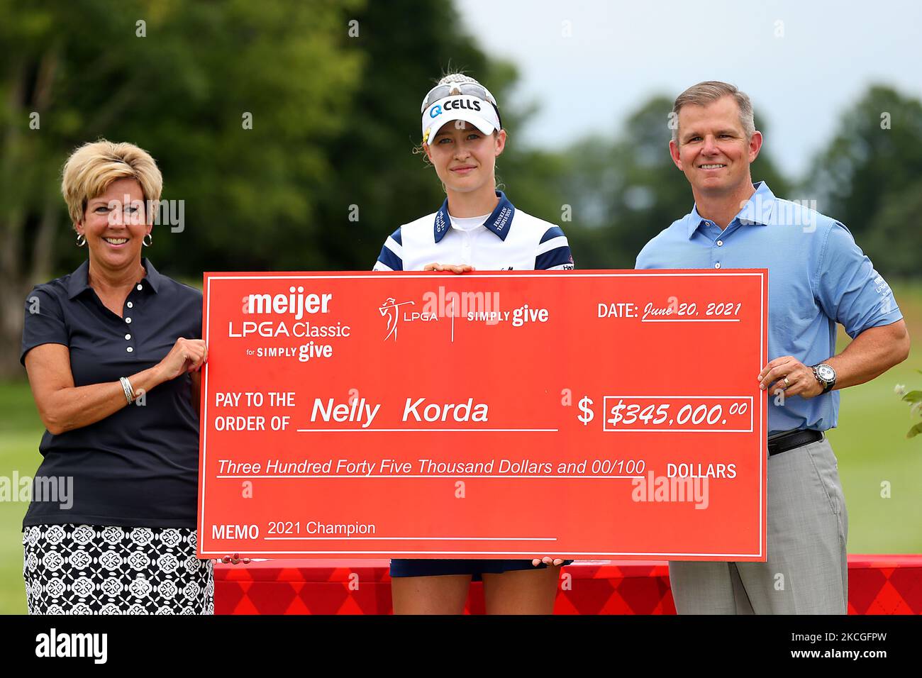 Nelly Korda poses with the ceremonial check on the course after winning the Meijer LPGA Classic