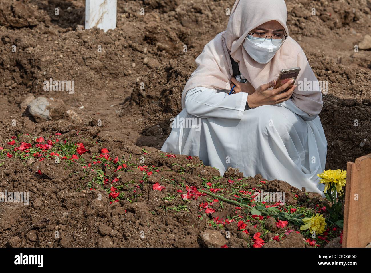 People at the Covid-19 graveyard in Jakarta, Indonesia, on June 28, 2021. (Photo by Donal Husni/NurPhoto) Stock Photo