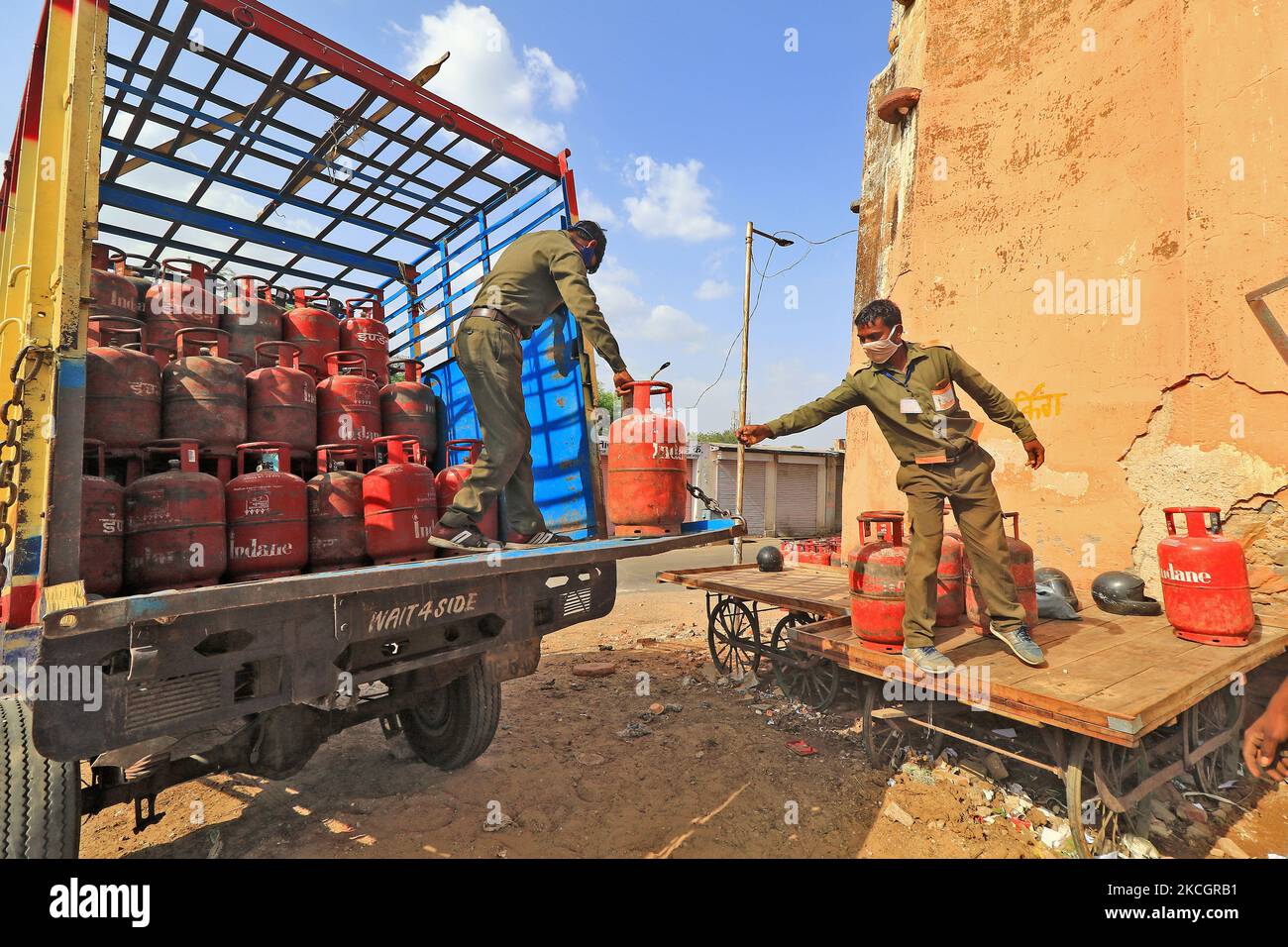 Workers unload LPG gas cylinders from a truck, in Jaipur, Rajasthan, India, on July 2, 2021. The price of non-subsidised LPG cylinders hiked by Rs 25.50 and commercial LPG cylinders hiked by Rs 84. (Photo by Vishal Bhatnagar/NurPhoto) Stock Photo