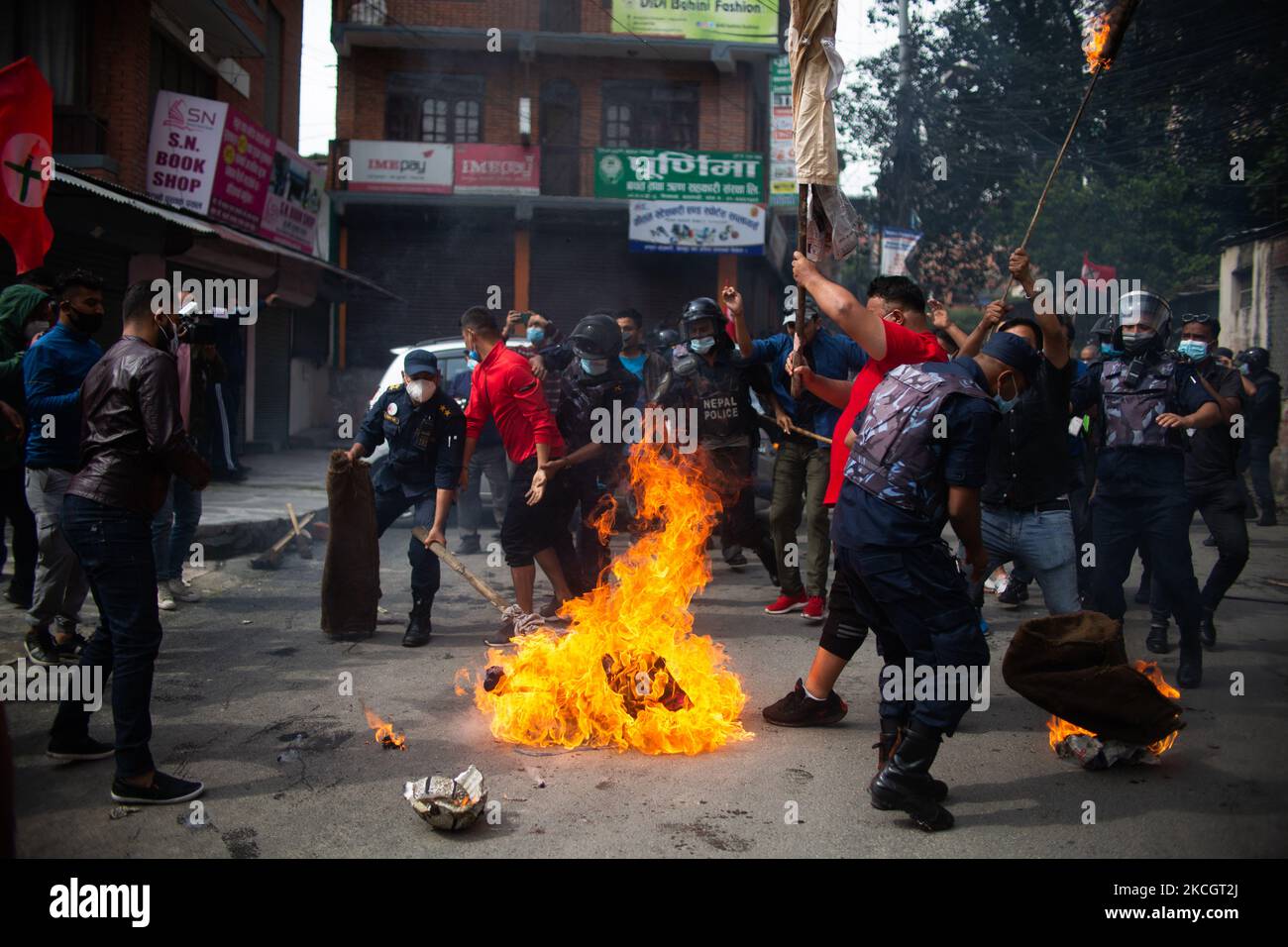 Nepal Police try to douse the burning effigy of Prime Minister KP Sharma Oli during a Protest against the dissolution of parliament in Kathmandu, Nepal on Saturday, July 3, 2021. (Photo by Rojan Shrestha/NurPhoto) Stock Photo