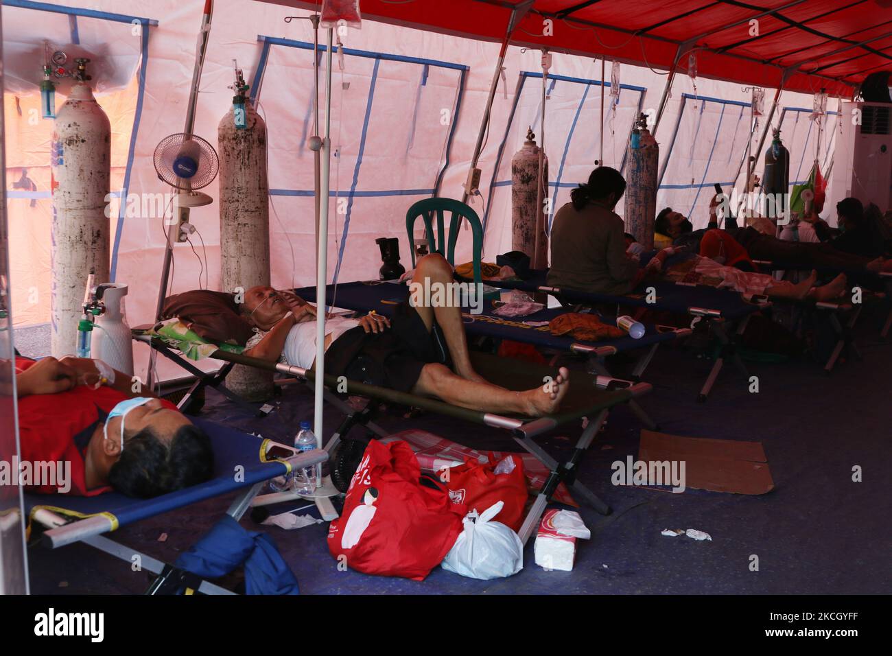 Covid-19 patients crowded the yard and emergency tents within the Regional General Hospital (RSUD) in Bekasi, West Java, on June 6, 2021. The availability of beds in hospitals is running low and the need for oxygen continues to increase. This happened in line with the drastic increase in Covid-19 cases in the last few weeks, every day Covid-19 patients entering the emergency room and Covid-19 handling tents ranged from 60-80 patients or exceeding the normal capacity of 40 patients. (Photo by Dasril Roszandi/NurPhoto) Stock Photo