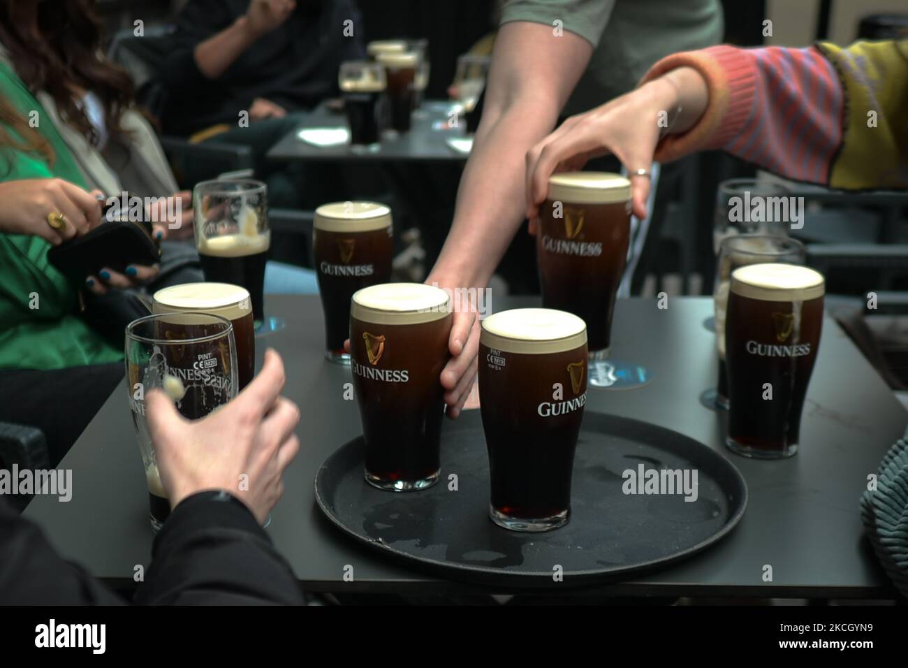 People enjoy drinking Guinness outside a pub in Dublin city center. On