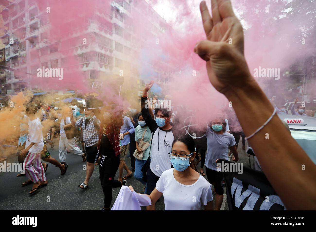Flash Mob Proteste Demonstrators make the three finger salute and hold flares during a ...